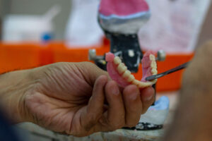 prosthodontist crafting a full arch implant model